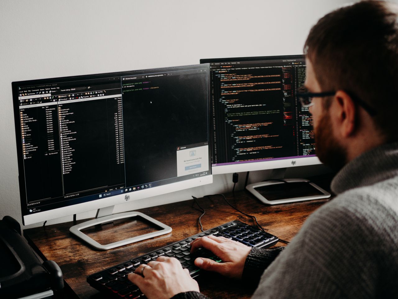 The Art of Drawing Readers In: Your attractive post title goes here Software developer typing code on dual monitors at a wooden desk.