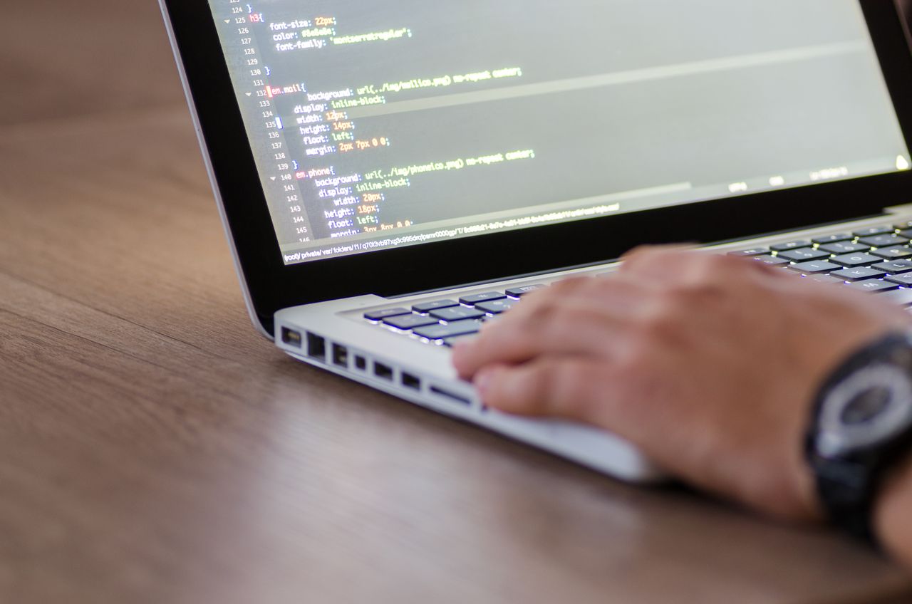 About Person coding on a laptop with HTML code on screen, showcasing development work.